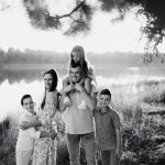 A joyful family enjoying time by the lake in a serene setting.
