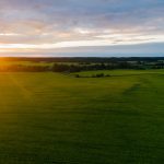A breathtaking sunrise over lush green fields, capturing nature's beauty at dawn.